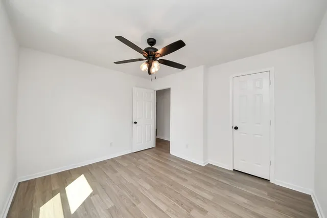 a view of a big room with wooden floor and a ceiling fan