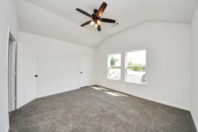 an empty room with a window and a fan