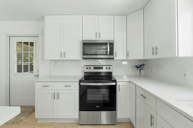 a kitchen with white cabinets and stainless steel appliances