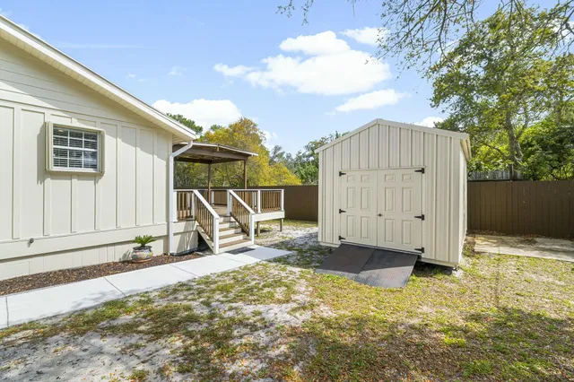 a view of a house with backyard and wooden fence