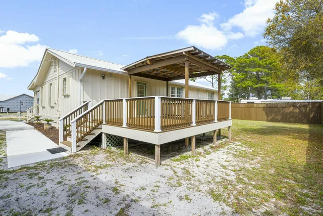 a view of a house with a yard and wooden fence