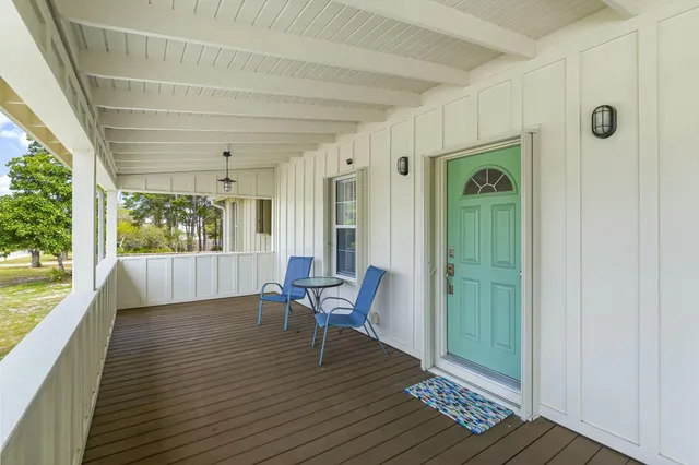 a view of a hallway with wooden floor and windows