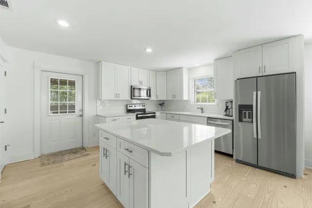 a kitchen with kitchen island a sink stove and refrigerator