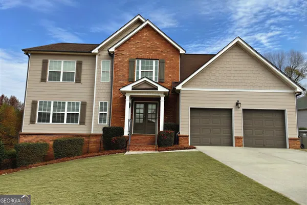 a front view of a house with a yard and garage