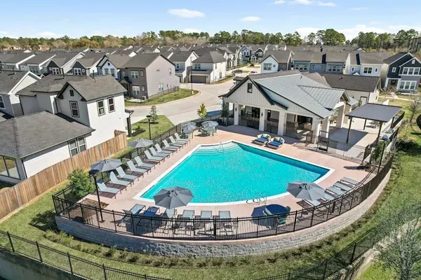 an aerial view of a house with a swimming pool a yard and lake view