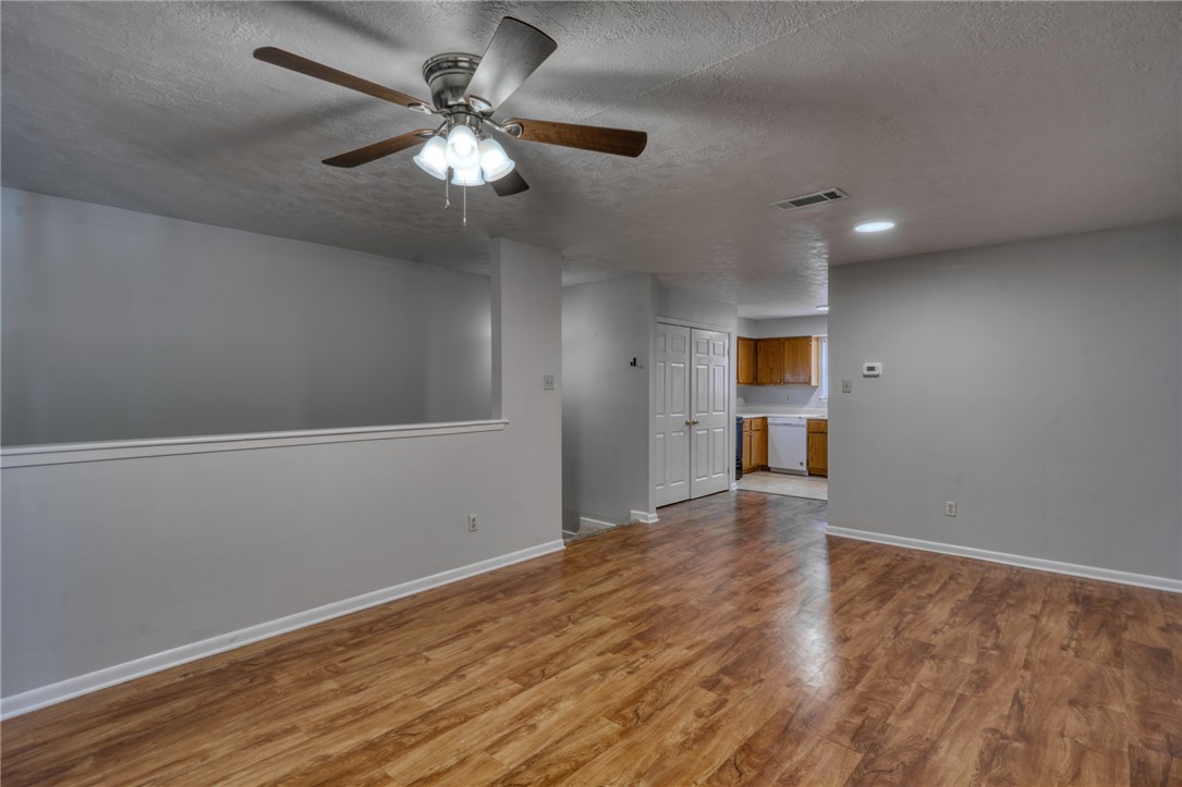 910 Spring Loop, Unit B College Station, TX 77840 - Photo 4 of 10 Empty room with light wood-style floors, a textured ceiling, and a ceiling fan