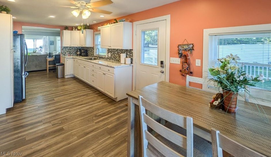 41 Poplar Street Huron, OH 44839 - Photo 2 of 37 Kitchen with freestanding refrigerator, ceiling fan, white cabinets, wood-style flooring, and backsplash