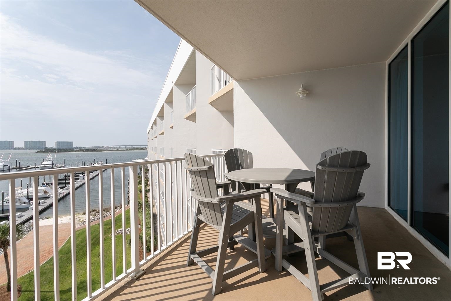 27800 Canal Road, Unit 411 Orange Beach, AL 36561 - Photo 15 of 49 Private balcony with water frontage featuring a white metal railing, an outdoor wall light fixture, and floor-to-ceiling glass sliding doors