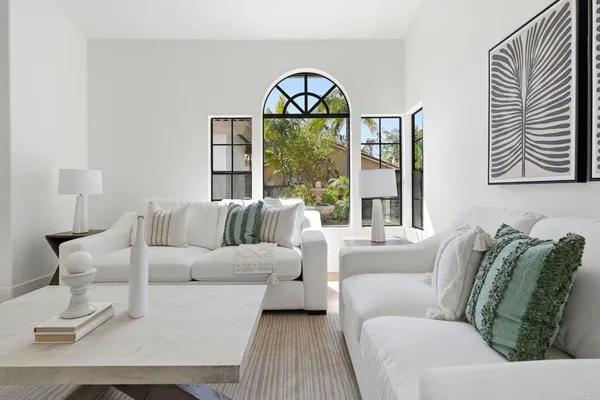 a living room with furniture a fireplace and a large window