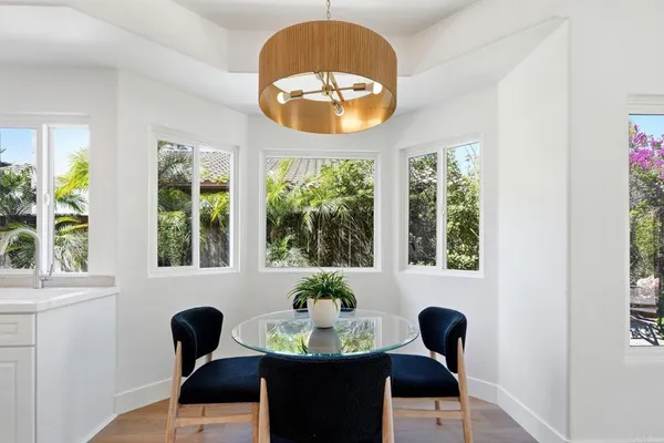 a kitchen with stainless steel appliances granite countertop a stove a refrigerator a sink a dining table and chairs