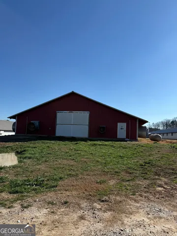a view of a hallway with wooden floor and a livingroom with furniture