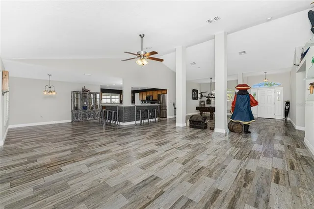 a kitchen with stainless steel appliances kitchen island granite countertop a table chairs sink and cabinets