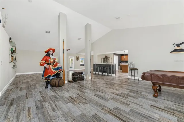 a living room with a table chairs and a wooden floor