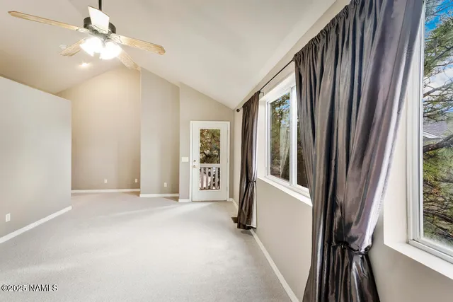 a view of a hallway with wooden floor and windows