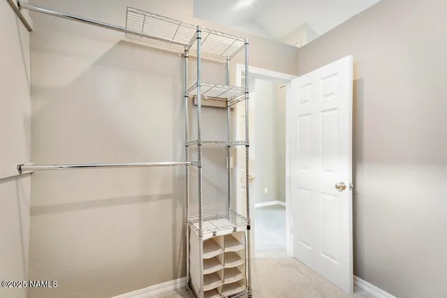 an empty room with chandelier fan and windows