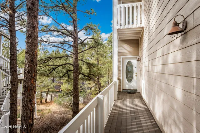 a view of a balcony with wooden floor and fence