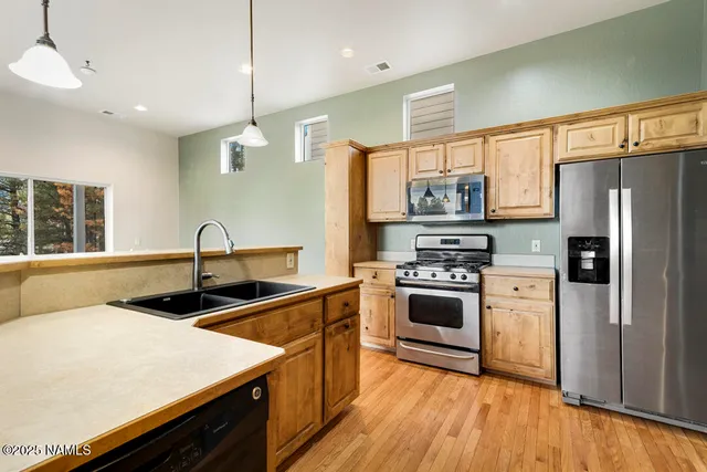 a kitchen with stainless steel appliances a stove sink and microwave