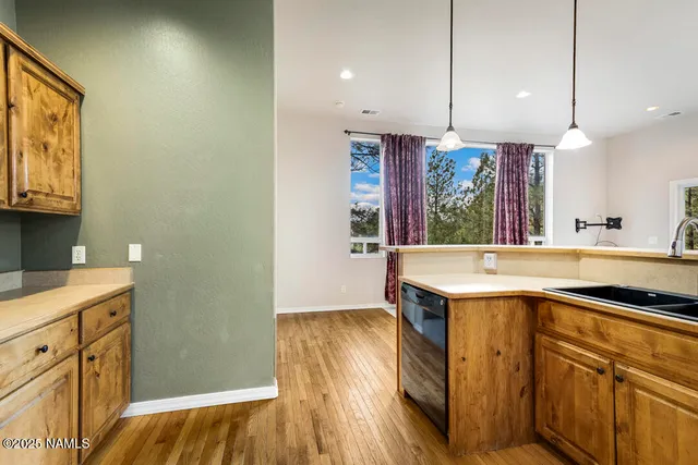 a kitchen with a sink a counter space appliances and cabinets