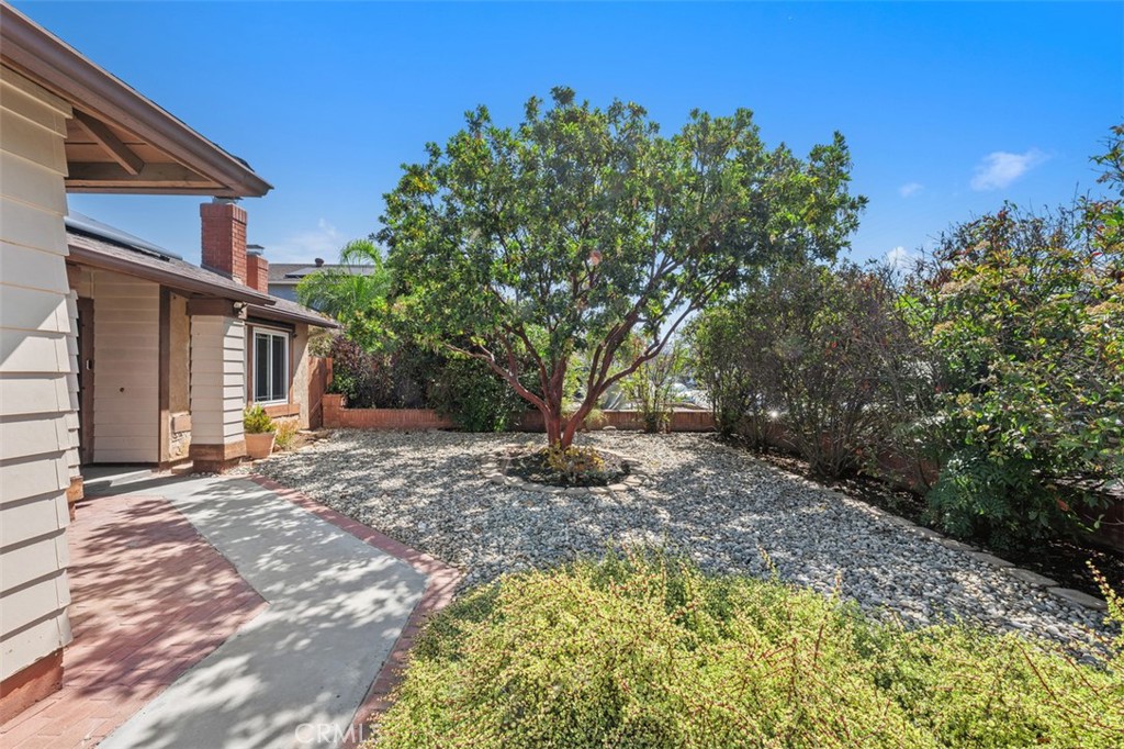 10424 2nd Street Santee, CA 92071 - Photo 5 of 28 Front walkway is framed by mature landscaping and natural shade, creating a peaceful path to the entry. This outdoor space feels private and welcoming.