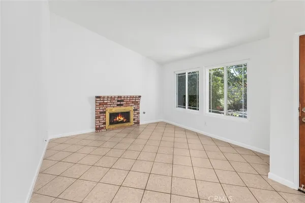 a view of an empty room with a fireplace and a window