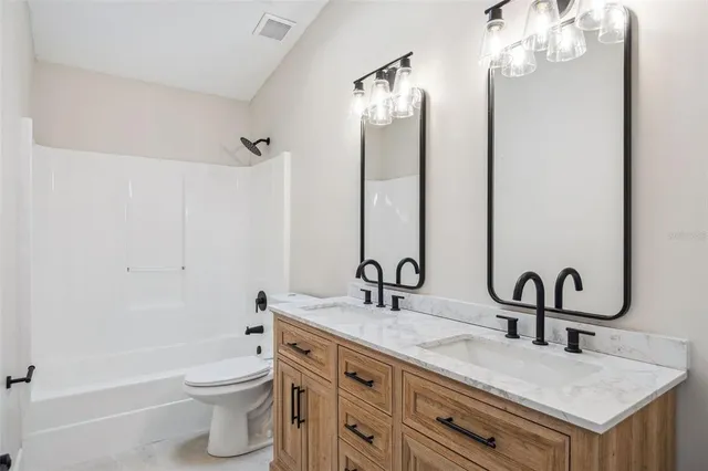 a bathroom with a double vanity sink mirror and toilet