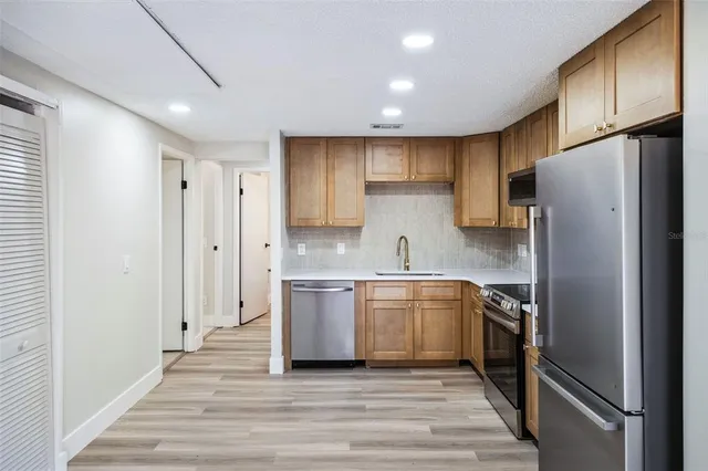 a kitchen with stainless steel appliances granite countertop a refrigerator and a sink