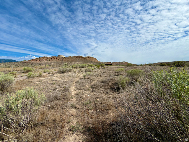 600 East E Street Moroni, UT 84646 - Photo 37 of 38 Expansive land parcel featuring natural desert vegetation, a visible dirt path, and distant rocky hills under a broad sky