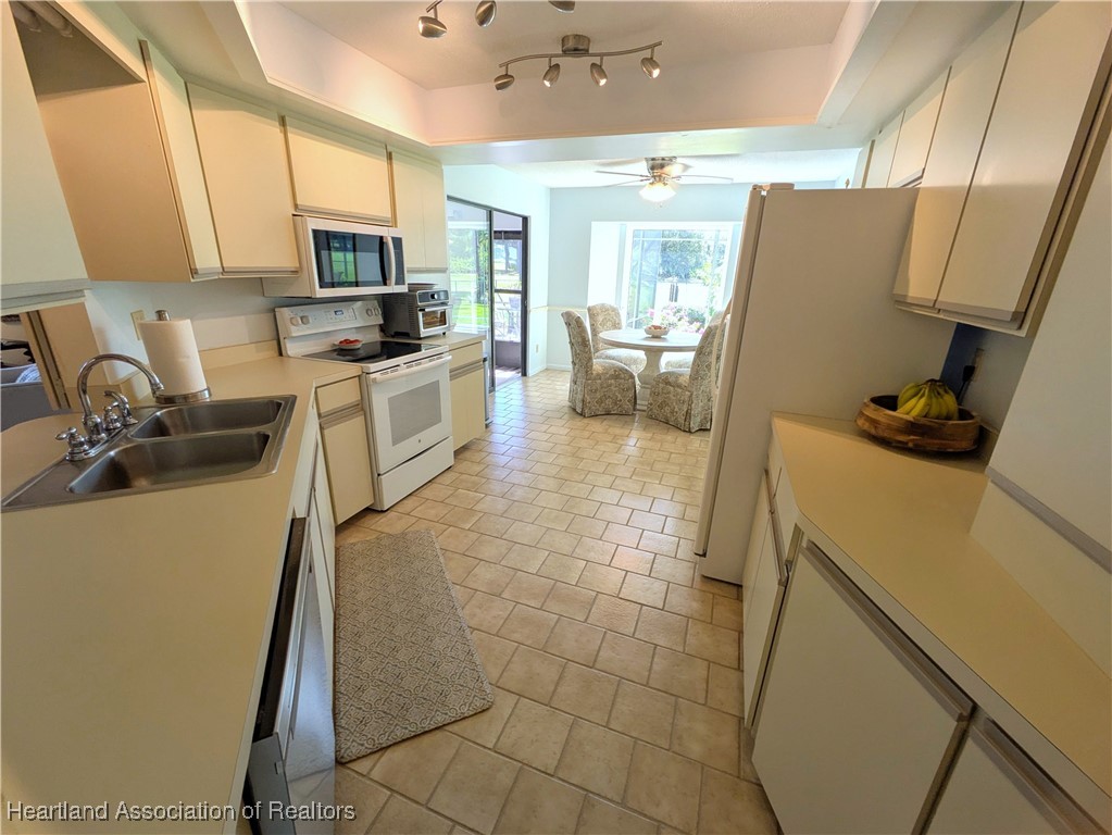 2708 Par Road Sebring, FL 33872 - Photo 7 of 33 a kitchen with a sink a stove a microwave a refrigerator a counter top space and cabinets