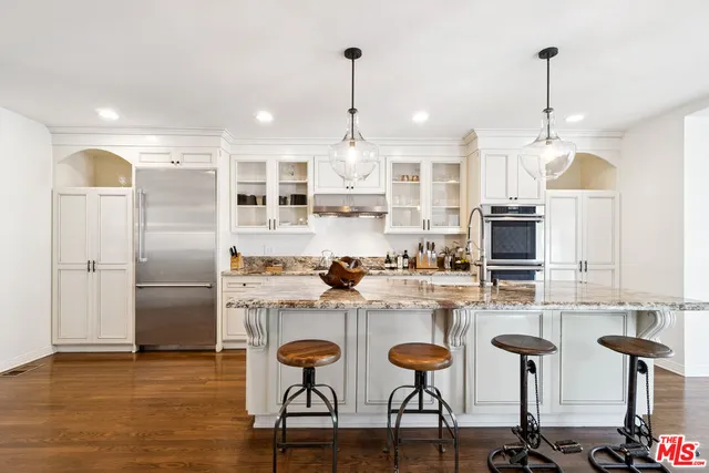 a kitchen with refrigerator a table and chairs