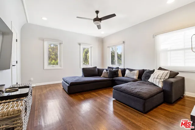 a spacious bedroom with a bed and wooden floor