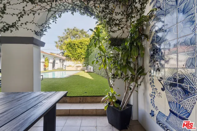 a view of an empty room with kitchen and window
