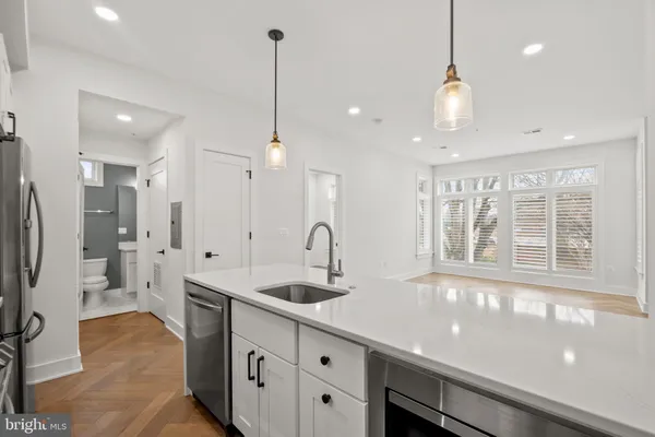 a kitchen with stainless steel appliances a sink a counter top space and a window
