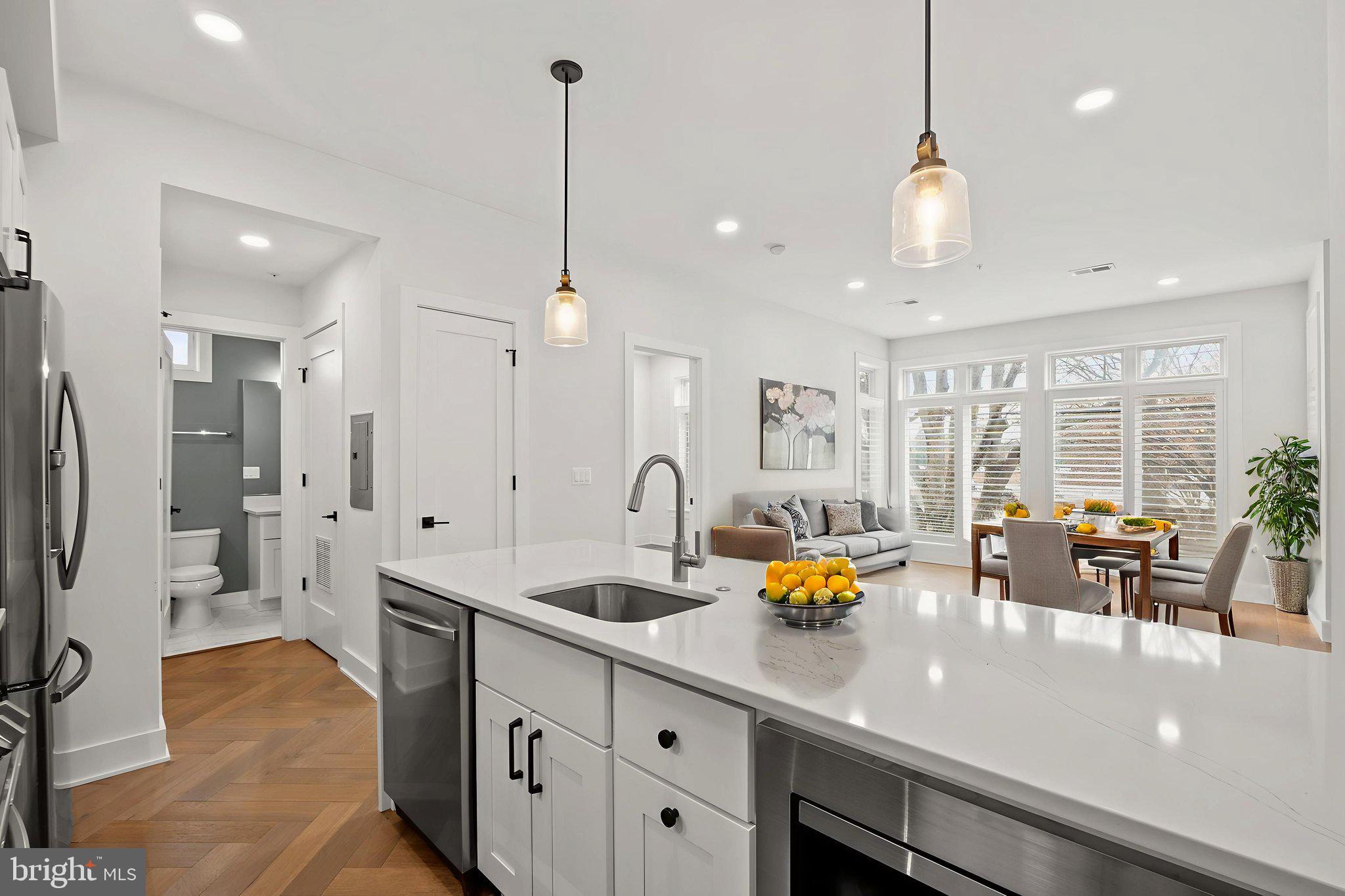 4315 Harrison Street Northwest, Unit 5 Washington, DC 20015 - Photo 15 of 33 a kitchen with stainless steel appliances a sink a counter top space and living room view