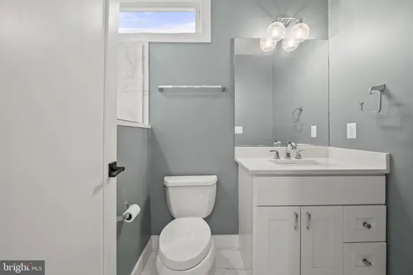 a bathroom with a toilet a sink and mirror
