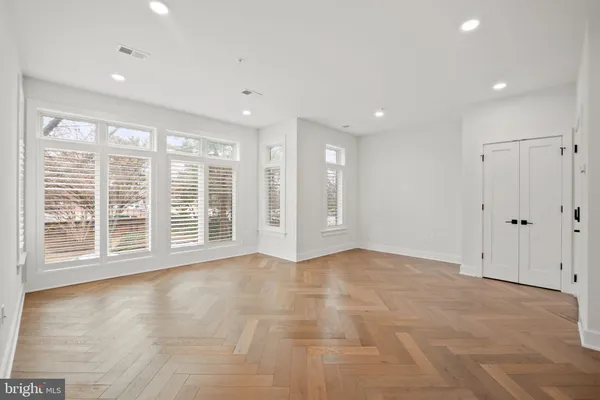 a view of an empty room with a window and a kitchen