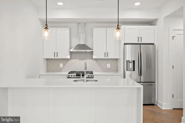a kitchen with stainless steel appliances a refrigerator a sink and a stove