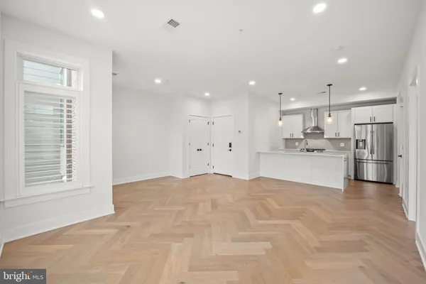 a view of kitchen with kitchen island a sink stainless steel appliances and cabinets
