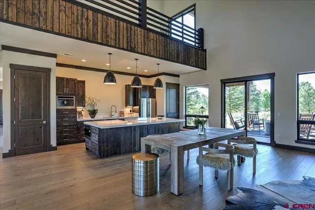 a dining hall with couches wooden floor and a dining table with wooden floor
