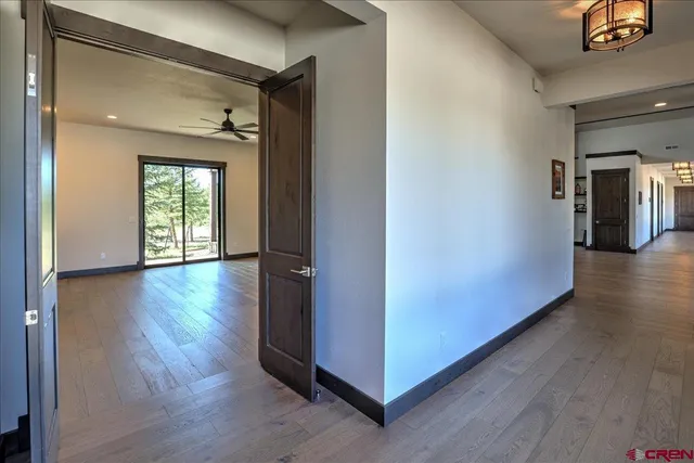 a view of a hallway with wooden floor and stairs