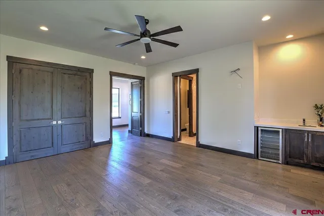 a view of a livingroom with wooden floor and a ceiling fan