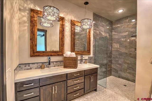 a bathroom with a double vanity sink mirror and shower