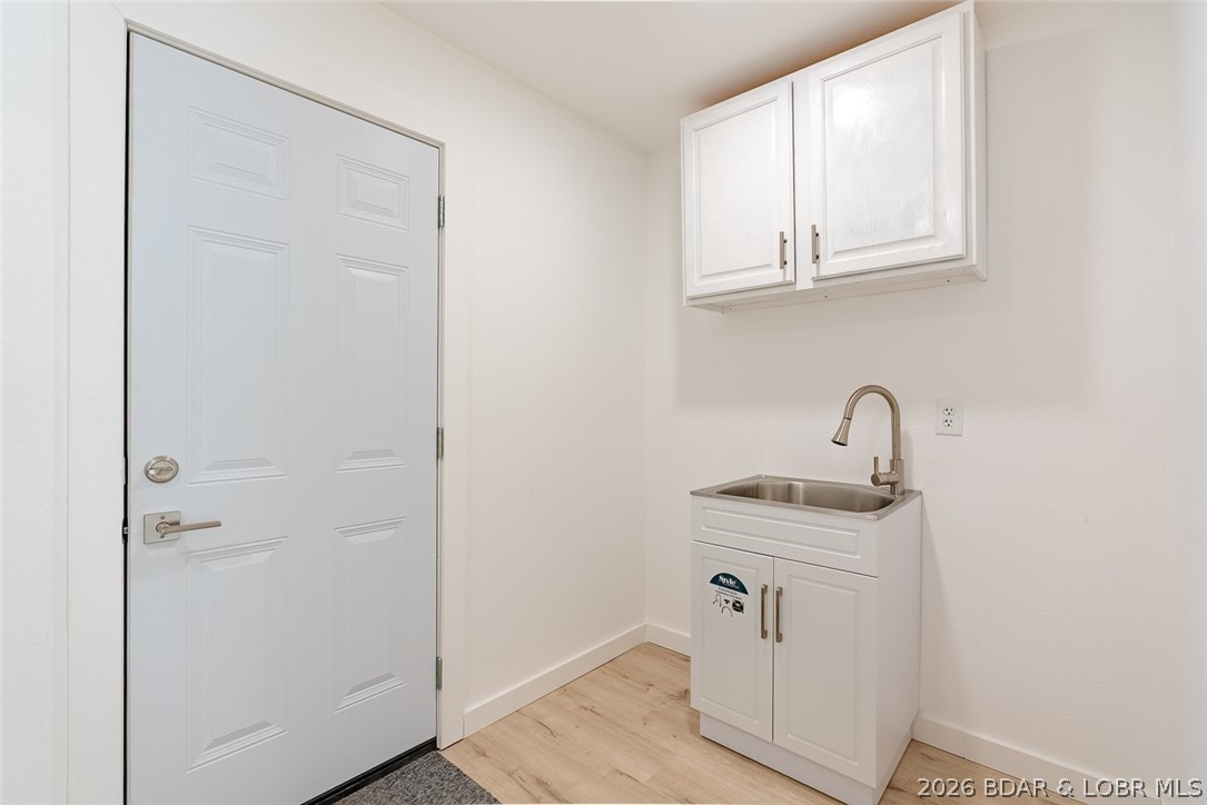 131 Frudeger Road Lake Ozark, MO 65049 - Photo 30 of 78 Laundry room has cabinets and sink and door to 2 c