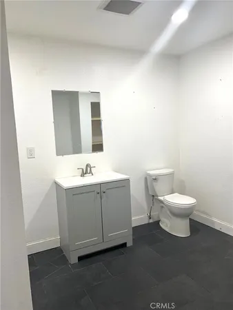 a bathroom with a toilet a sink and mirror