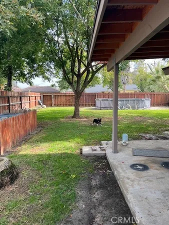 a view of a house with backyard and a large tree
