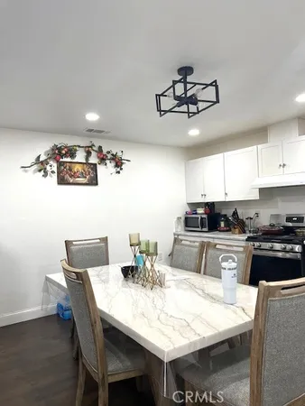 a kitchen with a dining table cabinets and stainless steel appliances