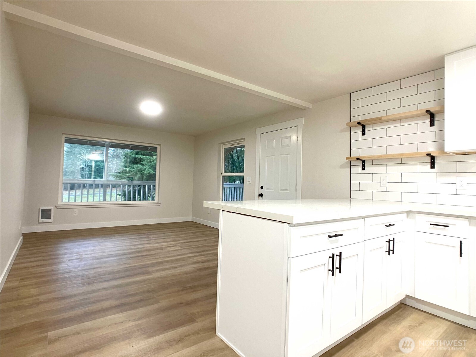1471 Southeast Binns Swiger Loop Road Shelton, WA 98584 - Photo 10 of 25 a kitchen with kitchen island a sink wooden floor and a large window