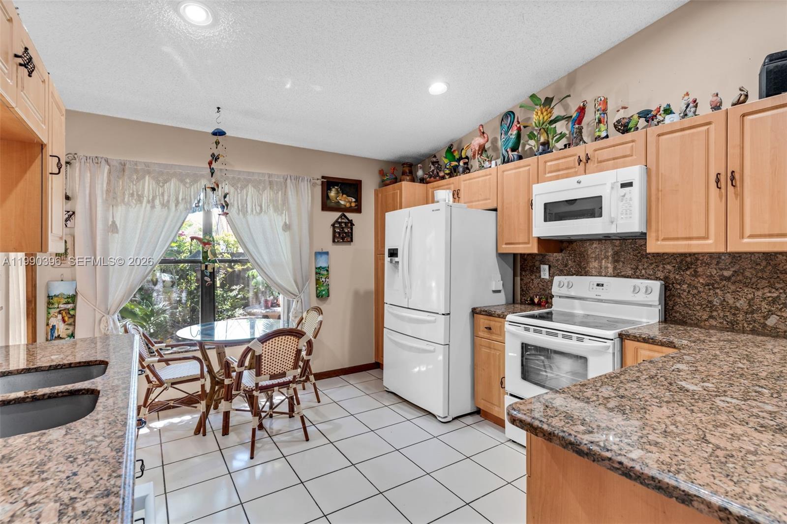 15012 Southwest 45th Lane Miami, FL 33185 - Photo 12 of 43 a kitchen with stainless steel appliances granite countertop a stove a refrigerator and a microwave