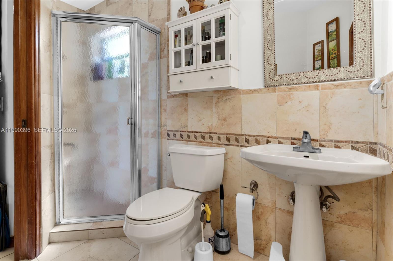 15012 Southwest 45th Lane Miami, FL 33185 - Photo 15 of 43 a bathroom with a sink and mirror with toilet