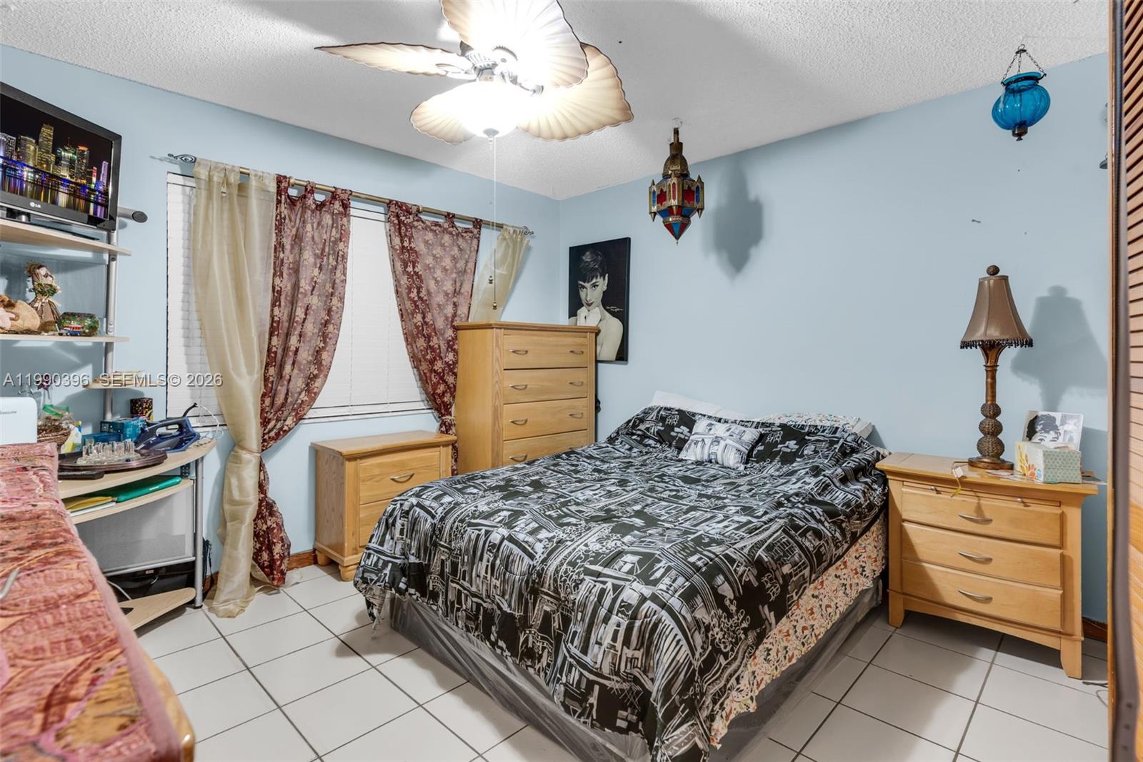 15012 Southwest 45th Lane Miami, FL 33185 - Photo 20 of 43 a bedroom with a bed and a dresser