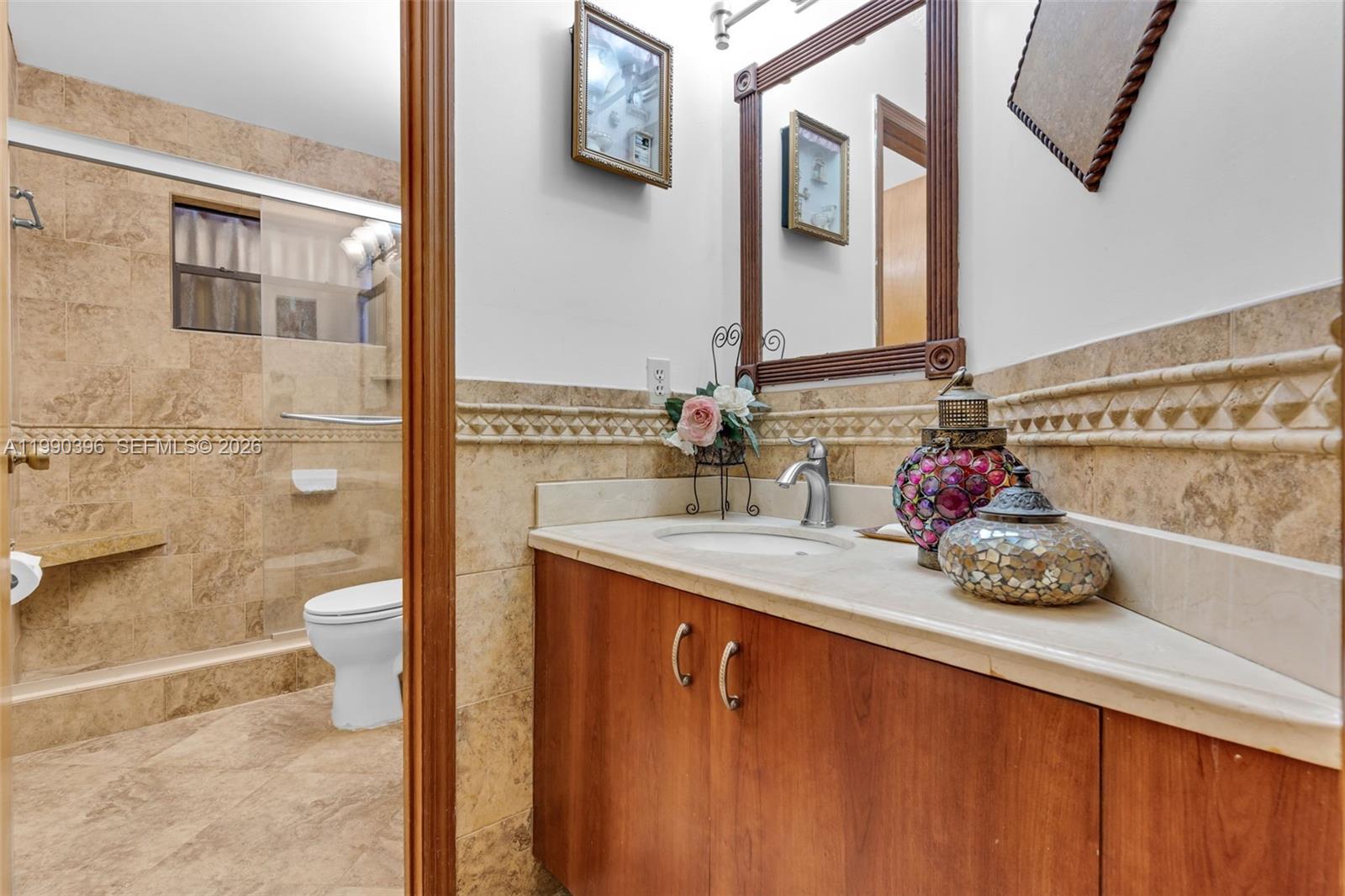 15012 Southwest 45th Lane Miami, FL 33185 - Photo 22 of 43 a bathroom with a granite countertop sink a toilet and a mirror